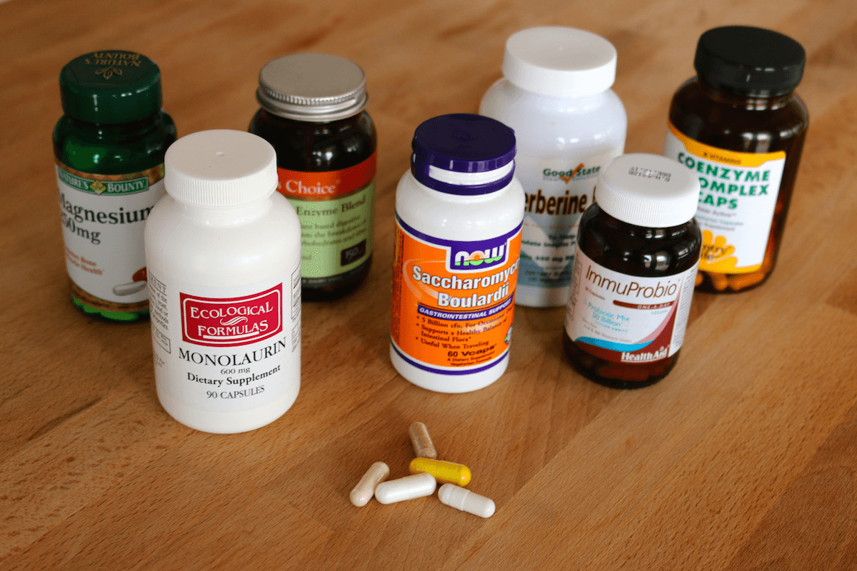 Bottles of probiotic supplement pills on a wooden table